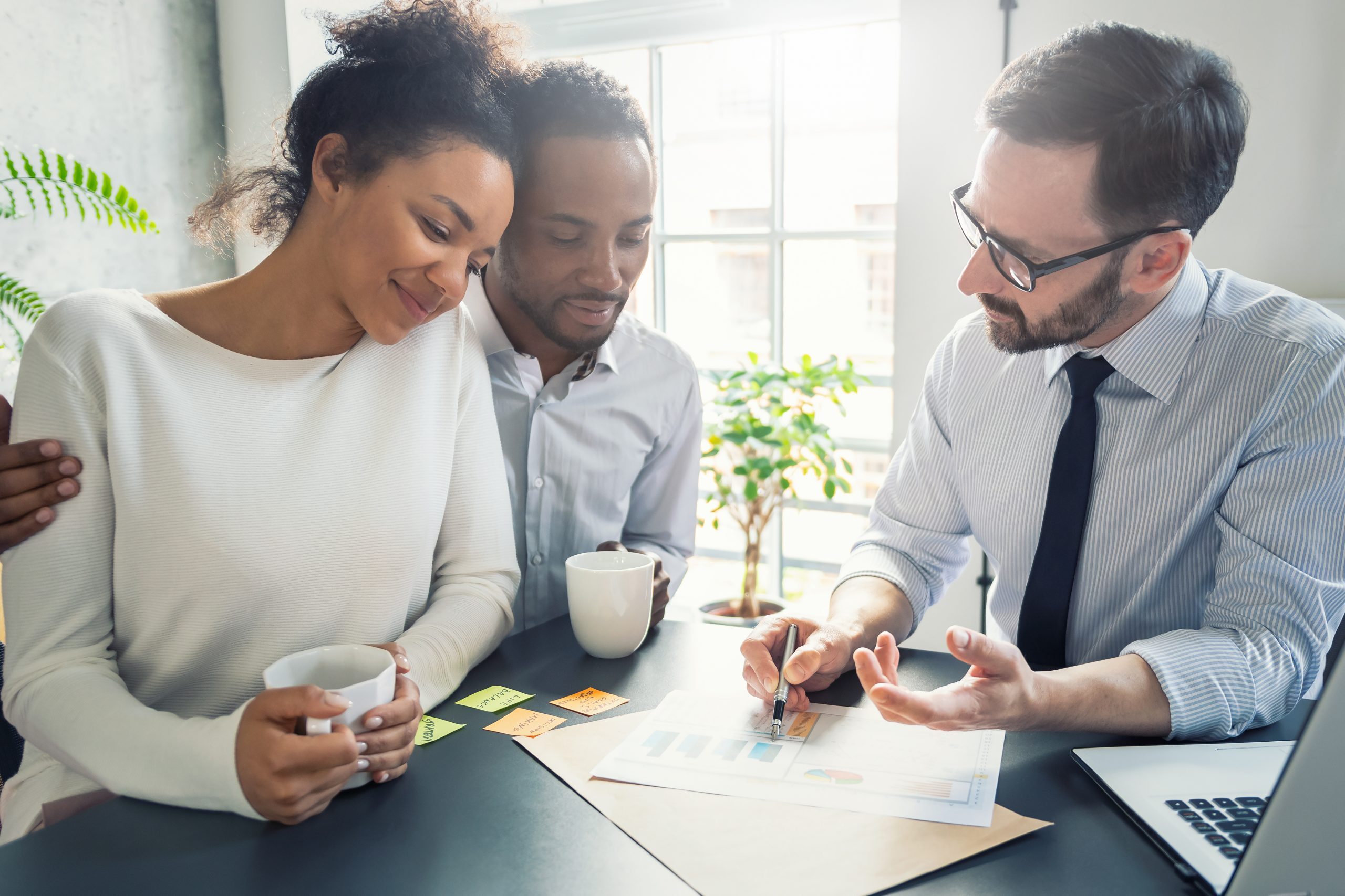 Smiling couple with advisor at desk